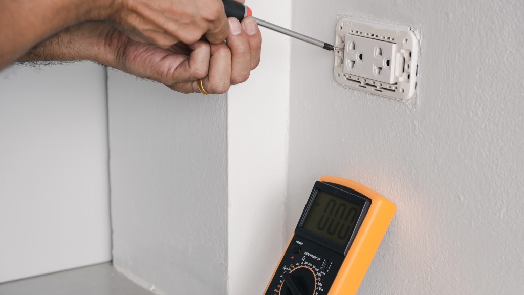 Électricien installant une prise électrique dans une maison